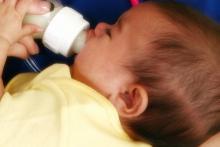 A baby drinks from a bottle