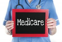 A nurse holding up a sign that says Medicare