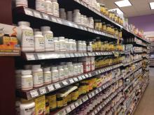 A grocery store aisle of supplements is shown.