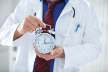 A doctor holds an alarm clock.