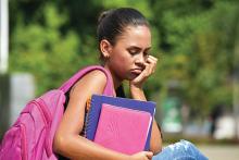 Sad teen with school books, backpack