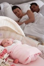 Newborn baby sleeping in parents' bedroom