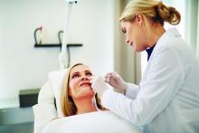 Doctor injecting filler into the cheek of a woman