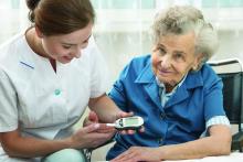 A health care provider attends to an elderly woman