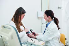 Pregnant woman in doctor's office, Doctor Measuring Blood Pressure