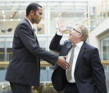 Business man making face at co-worker