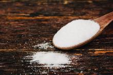 Spoon of salt on wood table