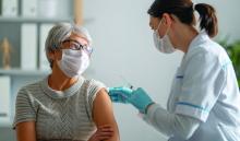 Doctor giving a senior woman a vaccination.