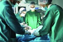 Surgeons work on a patient in the operating room