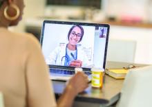 African American woman has medical consultation appointment video call with her doctor.