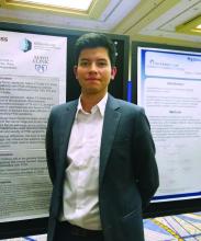 Freddy JK Toloza, MD, standing in front of his poster