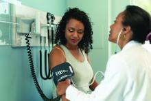 A health care provider takes a patient's blood pressure reading.