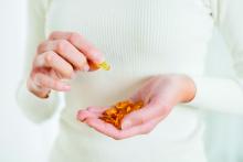 Woman hands holding fish oil omega-3 pills