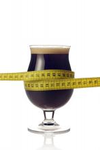 A glass of beer with tape measure around it