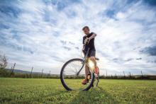 teen boy on a bike in a field