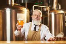 man in brewery holding a beer