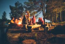 Group of campers around a fire at night