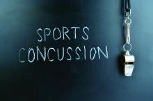 A blackboard reads &quot;sports concussion&quot; alongside a coach's whistle