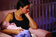 Woman with postpartum depression holding her baby.