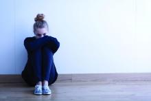 A depressed young woman sits alone