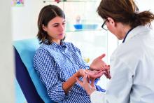 Doctor examining hands of a patient.