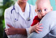 Mother holds baby while talking to a doctor