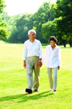 A senior couple walking in park