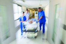 A patient is rushed through a hospital corridor.