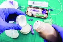 Nurse opening a bottle of enteral nutrition, palliative care in hospital