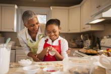 A woman makes cookies with her granddaughter