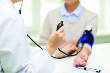 A doctor takes a blood pressure reading from a patient.