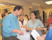 A burn specialist consults with staff in the ICU.