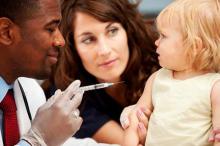 A cheerful physician giving a vaccine to a nervous -- but not crying -- little girl.