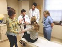 From left, rheumatologist Elinor Mody, rheumatologist-dermatologist Joseph Merola, resident Dr. Omar Badri, and nurse Kathleen Dufault visit with a patient at the Center for Skin and Related Musculoskeletal Diseases at Brigham and Women's Hospital, Boston.