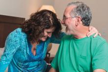 Happy mature couple sitting at their bedroom looking at each other