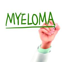 A hand is writing myeloma in green letters