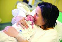 A mother holds her newborn baby.