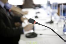 panel of men at a table with microphone