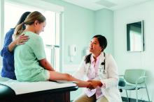 Pediatrician examining a girl's knee