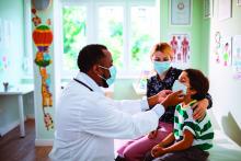 A pediatrician checks on a patient