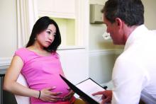 A pregnant woman listens to an obstetrician