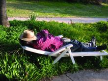 man sleeping outside on lounge chair