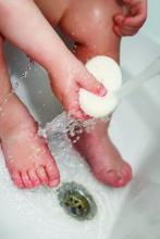 A toddler holds a bar of soap