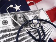 A stethoscope placed on paper money atop an American flag