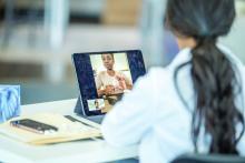 A health care provider consults with a patient via telemedicine.