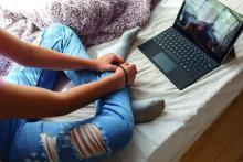 14 years old girl has psychotherapy session with her therapist via video call. She has rubber band on her wrist to prevent anxiety.