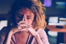 Tired young woman leaning head on hands