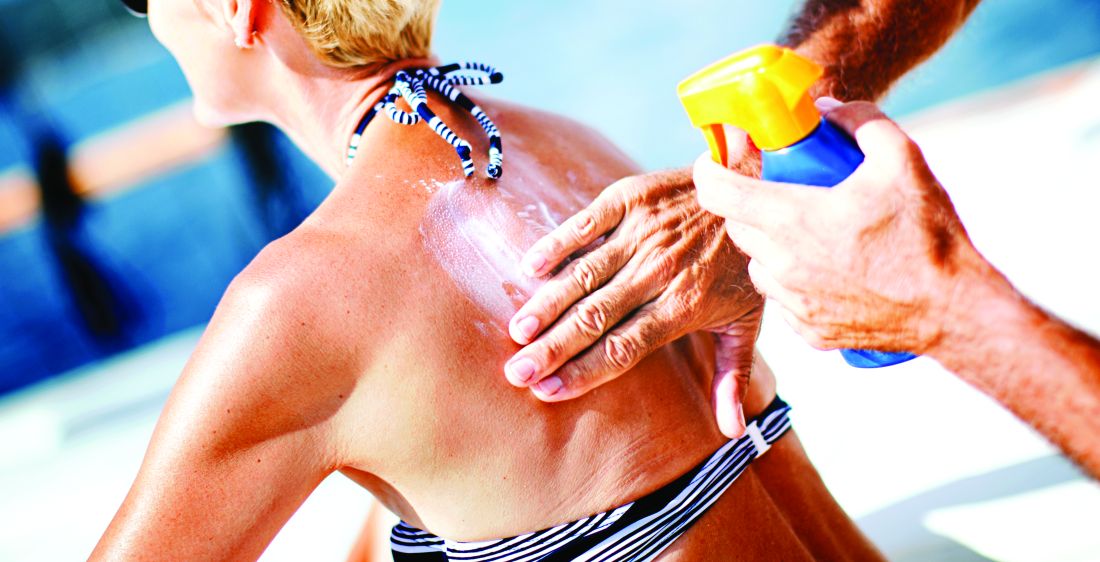 A woman has sunscreen applied to her back.