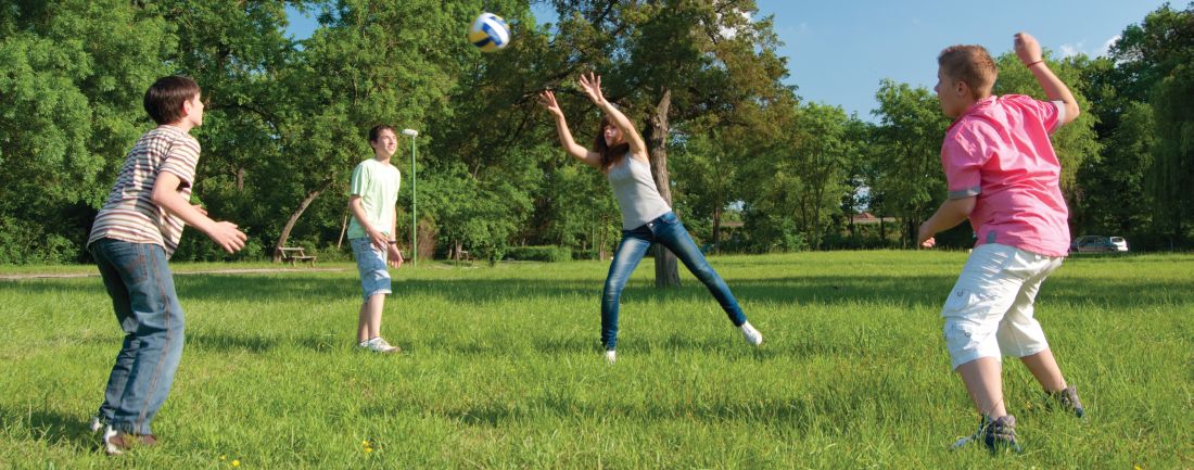 Teens playing with a ball in a park